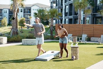 a man and a woman playing a game of shuffleboard on a lawn at Livano Avondale, Avondale, AZ